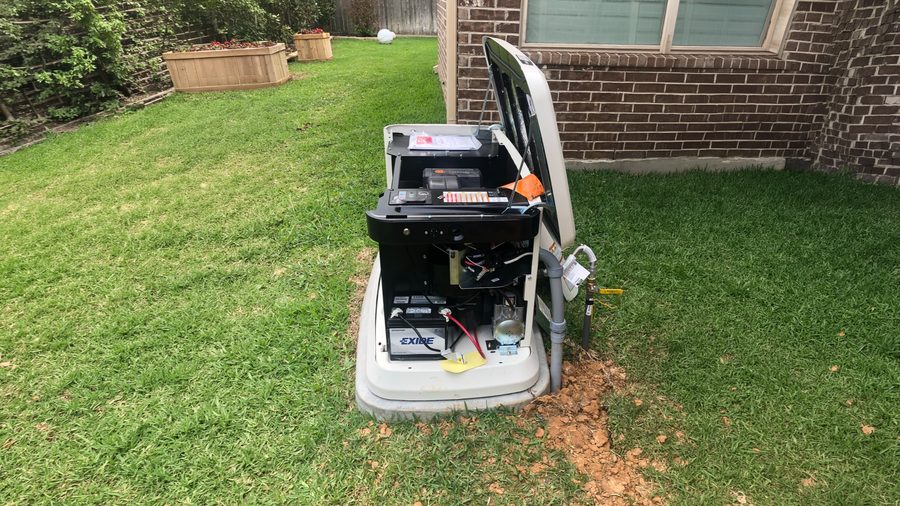A standby generator with its cover open during installation