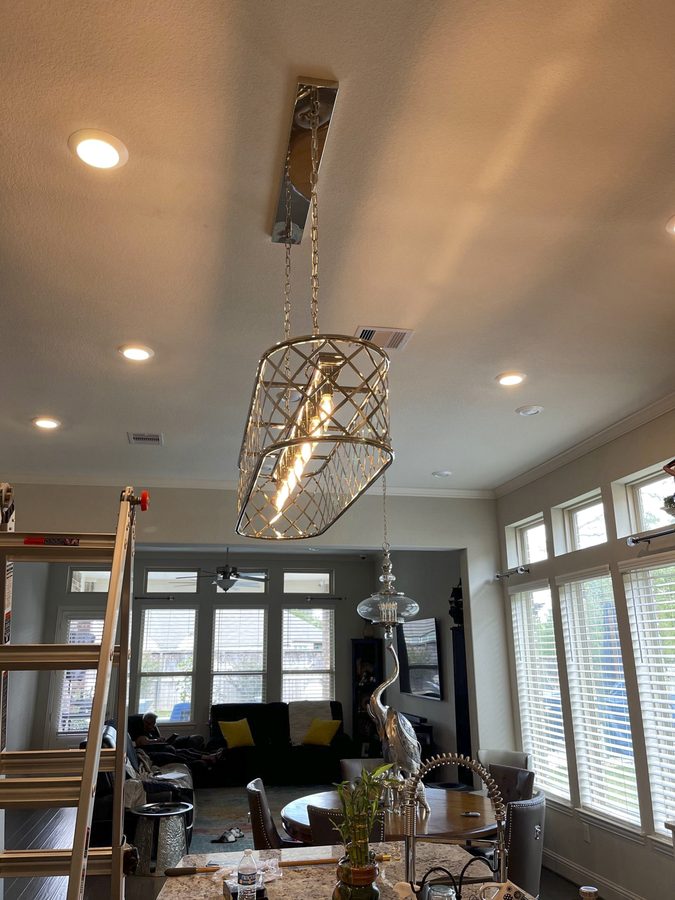 A lantern-style pendant over a dining area, with recessed lights in the ceiling