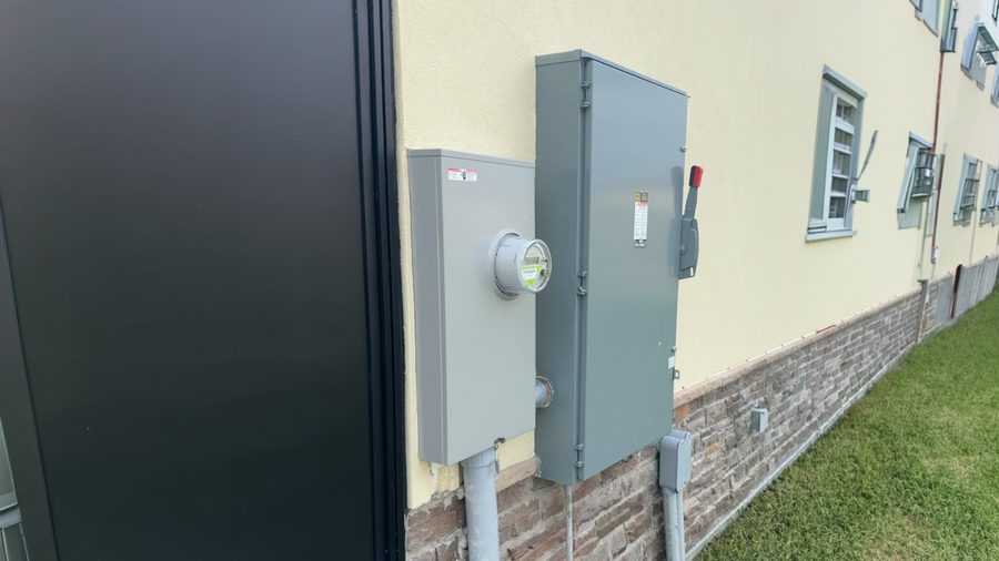 Meter and service disconnect mounted on the exterior wall of a commercial building